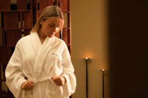 Cliente de roupão Float in num ambiente de spa com velas